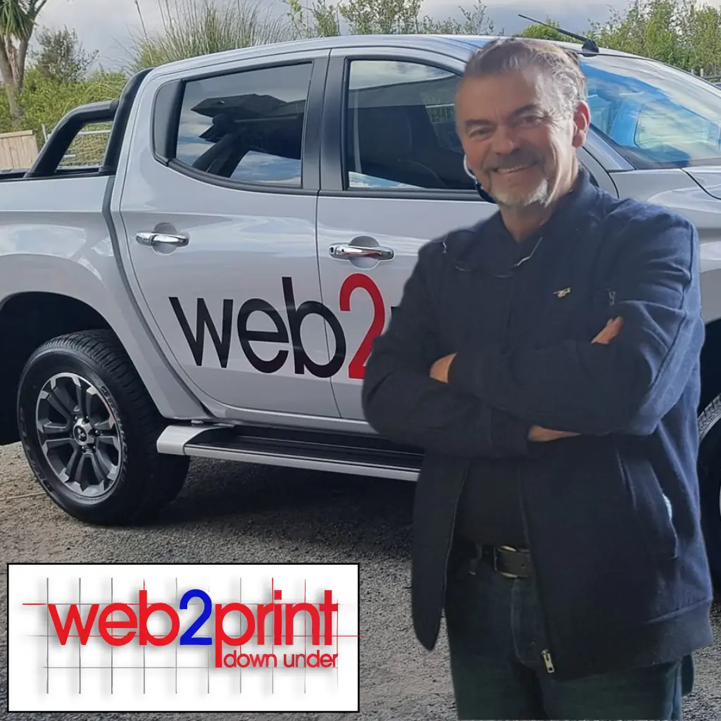 Tim Beere of Web2Print Signs & Printing smiling in front of a branded vehicle with company logo